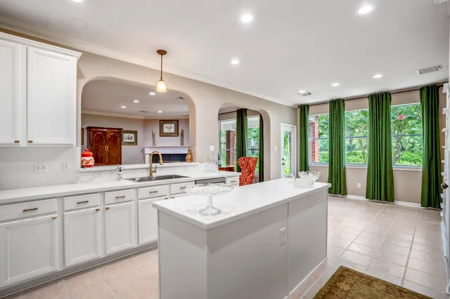 a large kitchen with stainless steel appliances kitchen island granite countertop a stove and a sink