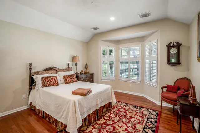a view of a house with a big yard plants and large trees