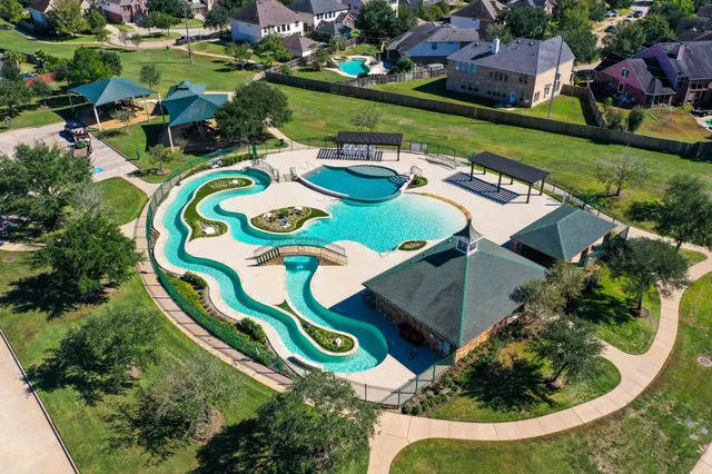an aerial view of residential house with outdoor space and trees all around