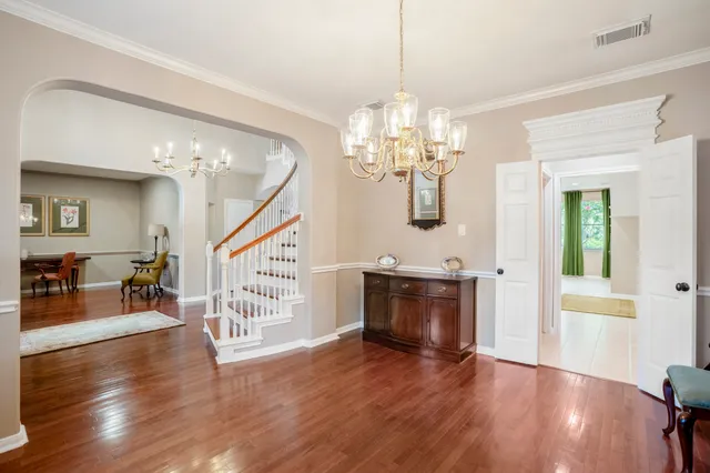 a view of a livingroom with furniture wooden floor and a chandelier
