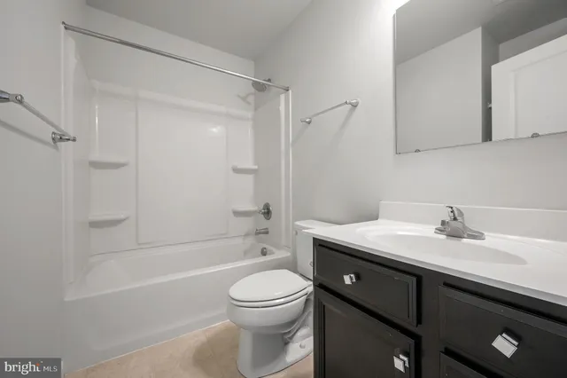 a bathroom with a granite countertop sink a toilet and shower