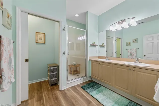 a bathroom with a double vanity sink mirror and shower