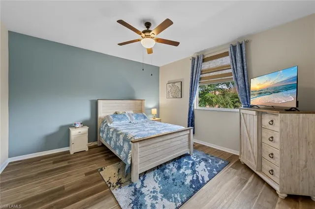 a bedroom with a bed and large windows