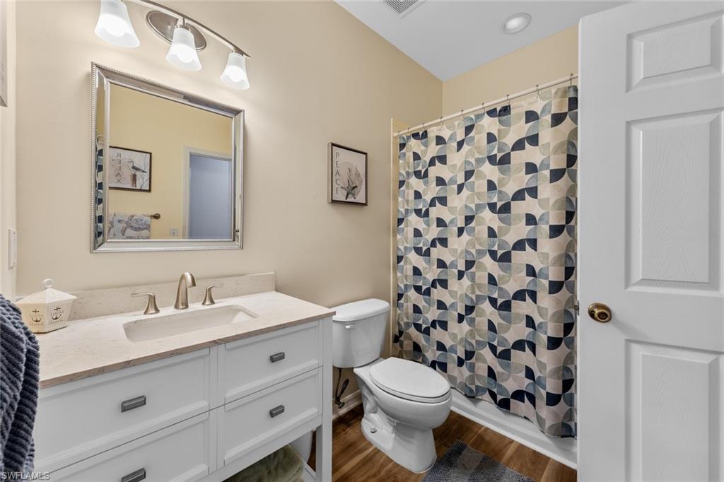 4306 Bellasol Circle, Unit 3422 Fort Myers, FL 33916 - Photo 21 of 41 Full bathroom featuring vanity, a shower with shower curtain, and dark wood-style flooring