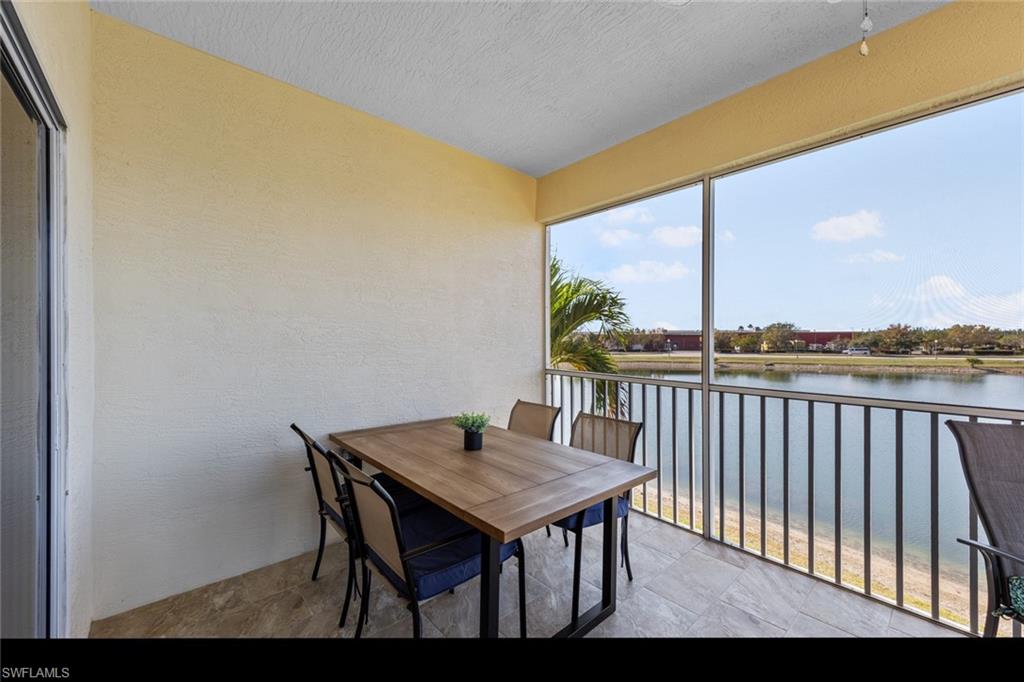 4306 Bellasol Circle, Unit 3422 Fort Myers, FL 33916 - Photo 25 of 41 Screened Lanai featuring a water view, a textured wall, a textured ceiling, and stone finish flooring