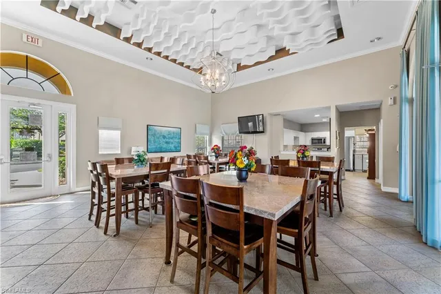 a view of a dining room and livingroom with furniture a rug a potted plant and a chandelier