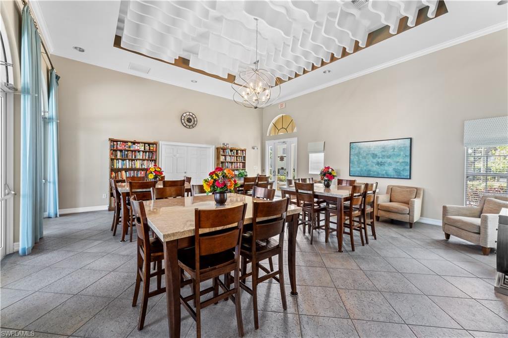 4306 Bellasol Circle, Unit 3422 Fort Myers, FL 33916 - Photo 37 of 41 Dining space with ornamental molding, a towering ceiling, and a chandelier