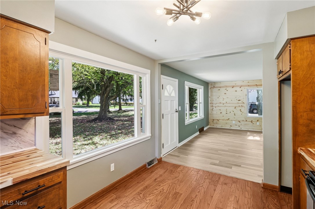 5898 Keller Road Akron, OH 44319 - Photo 6 of 32 Doorway featuring wooden walls, wood finished floors, and a chandelier