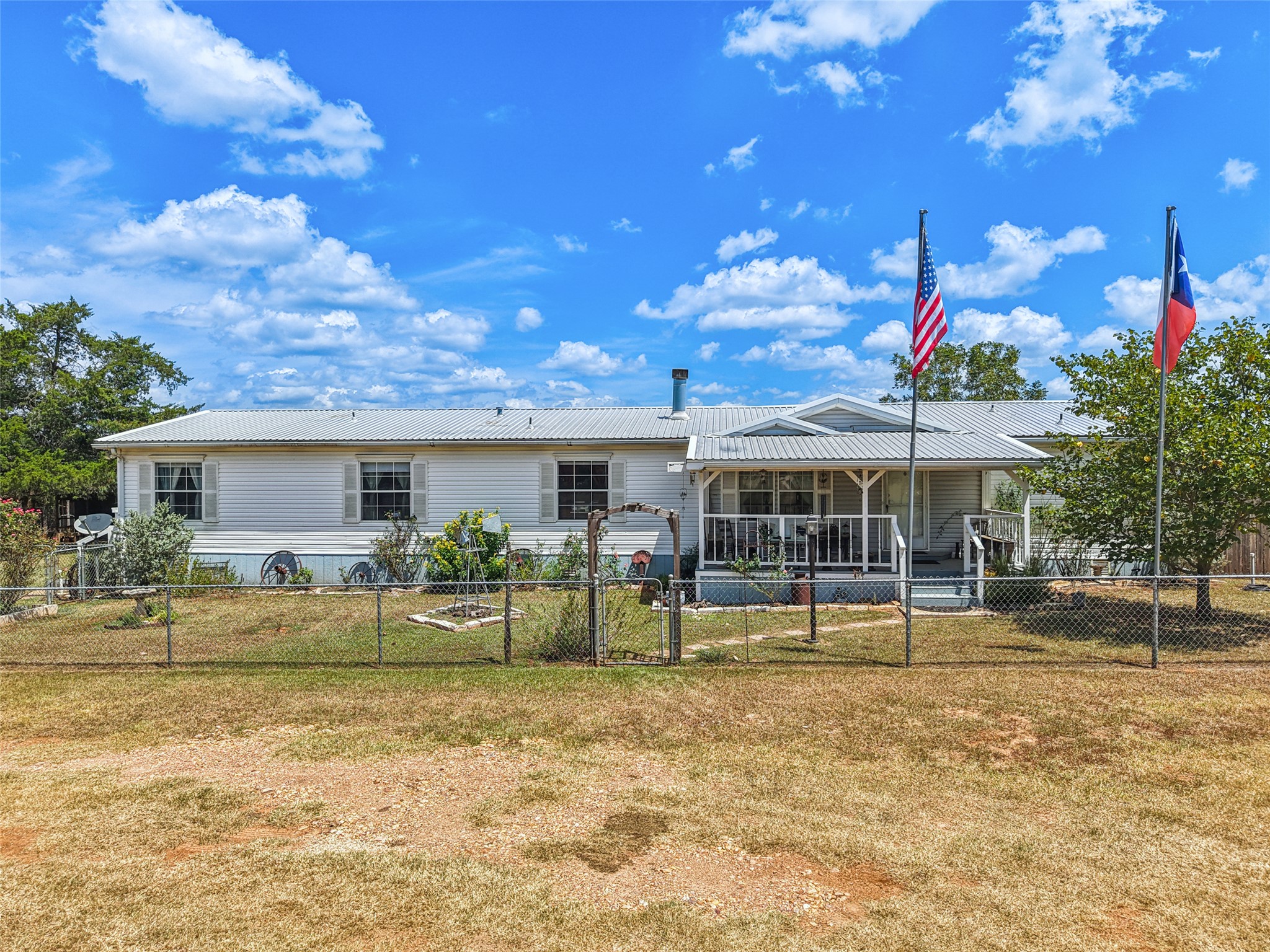 372 Hofferek Road Rosanky, TX 78953 - Photo 36 of 40 View of front of home featuring covered porch, a fenced front yard, a metal roof, and a gate