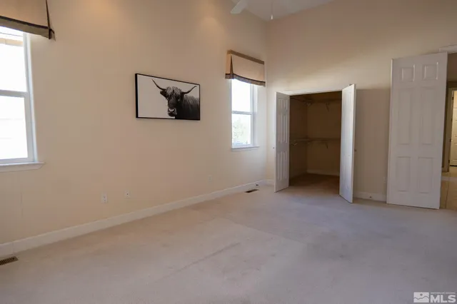 a bedroom with a bed and a mirror on dresser