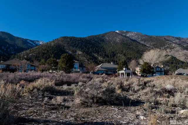 a view of a houses with yard and mountain view in back