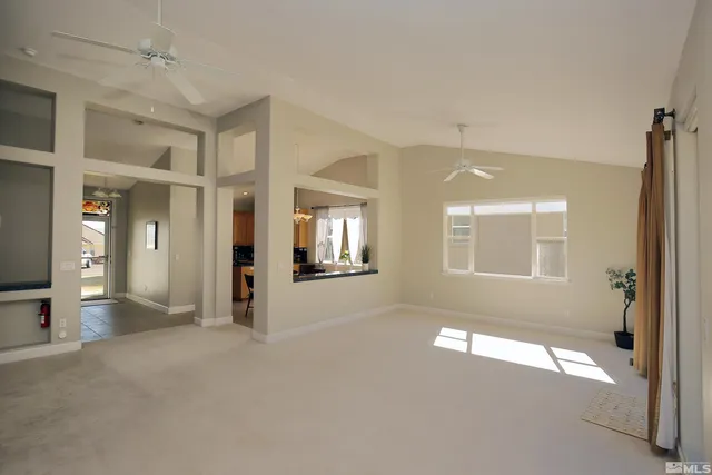 a view of livingroom and window with an empty room