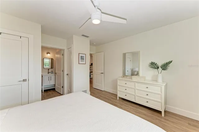 a spacious bedroom with a bed and a dresser