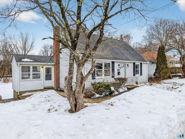 a front view of a house with a yard covered in snow