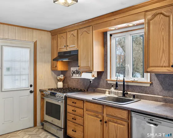 a kitchen with stainless steel appliances granite countertop a sink stove and cabinets