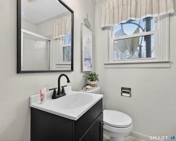 a bathroom with a sink mirror vanity and toilet