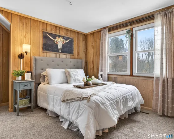 a bedroom with a large bed and a painting on the wall