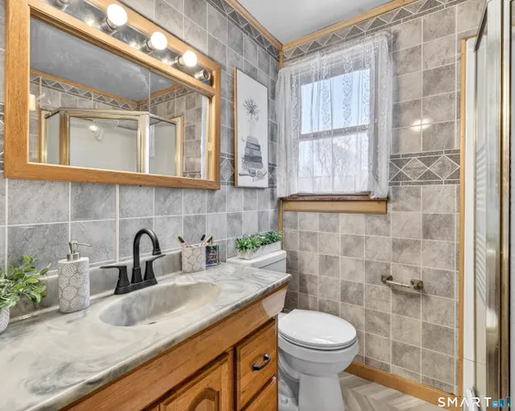 a bathroom with a granite countertop sink a toilet and shower