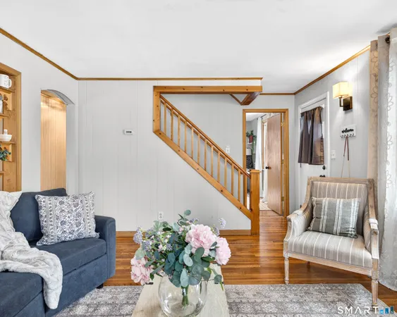 a living room with furniture flowerpot and wooden floor