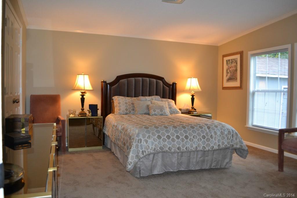 774 Sunderland Road Southwest Concord, NC 28027 - Photo 7 of 12 a bedroom with a bed and dresser with mirror