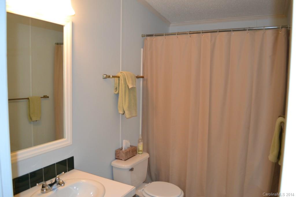 774 Sunderland Road Southwest Concord, NC 28027 - Photo 10 of 12 a white toilet sitting next to a shower curtain
