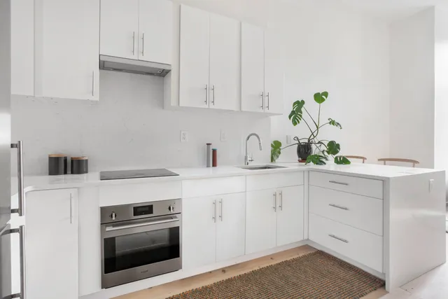 a kitchen with white cabinets and white appliances