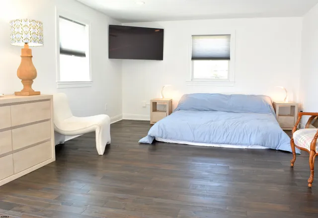 a living room with furniture a flat screen tv and a window