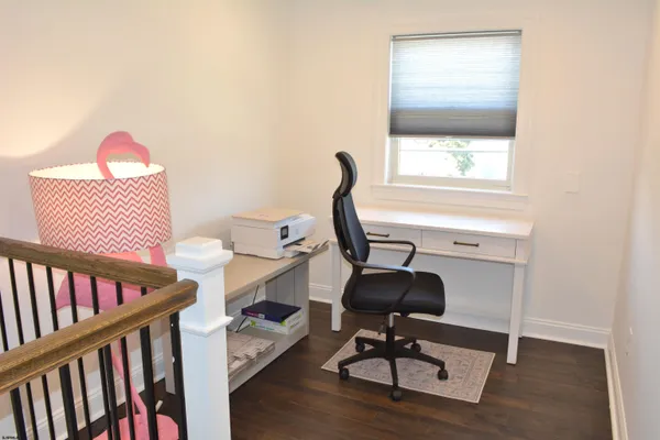 a view of a workspace with furniture and a window