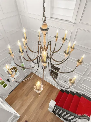 a view of a dining room with furniture a chandelier and wooden floor