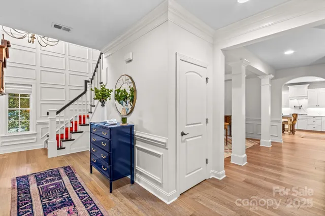 a dining room with wooden floor a chandelier a wooden table and chairs