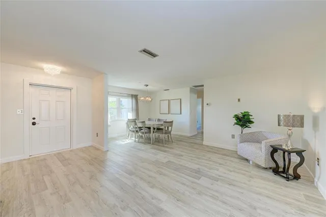 a living room with furniture and a table with wooden floor