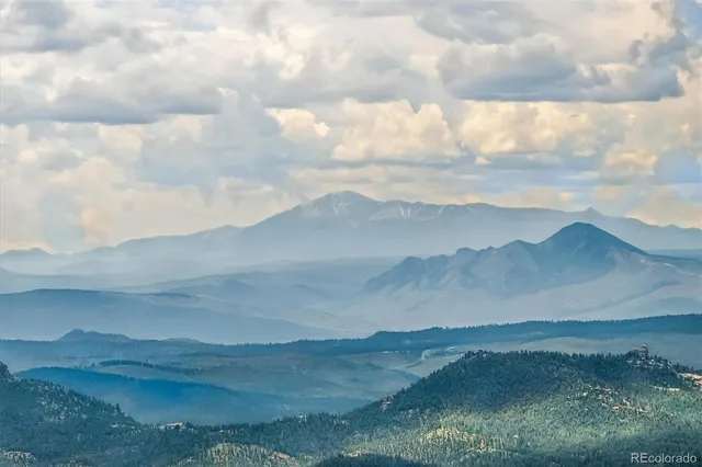 a view of a large mountain with lots of trees in the background