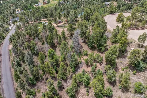 an aerial view of residential house with outdoor space and trees all around