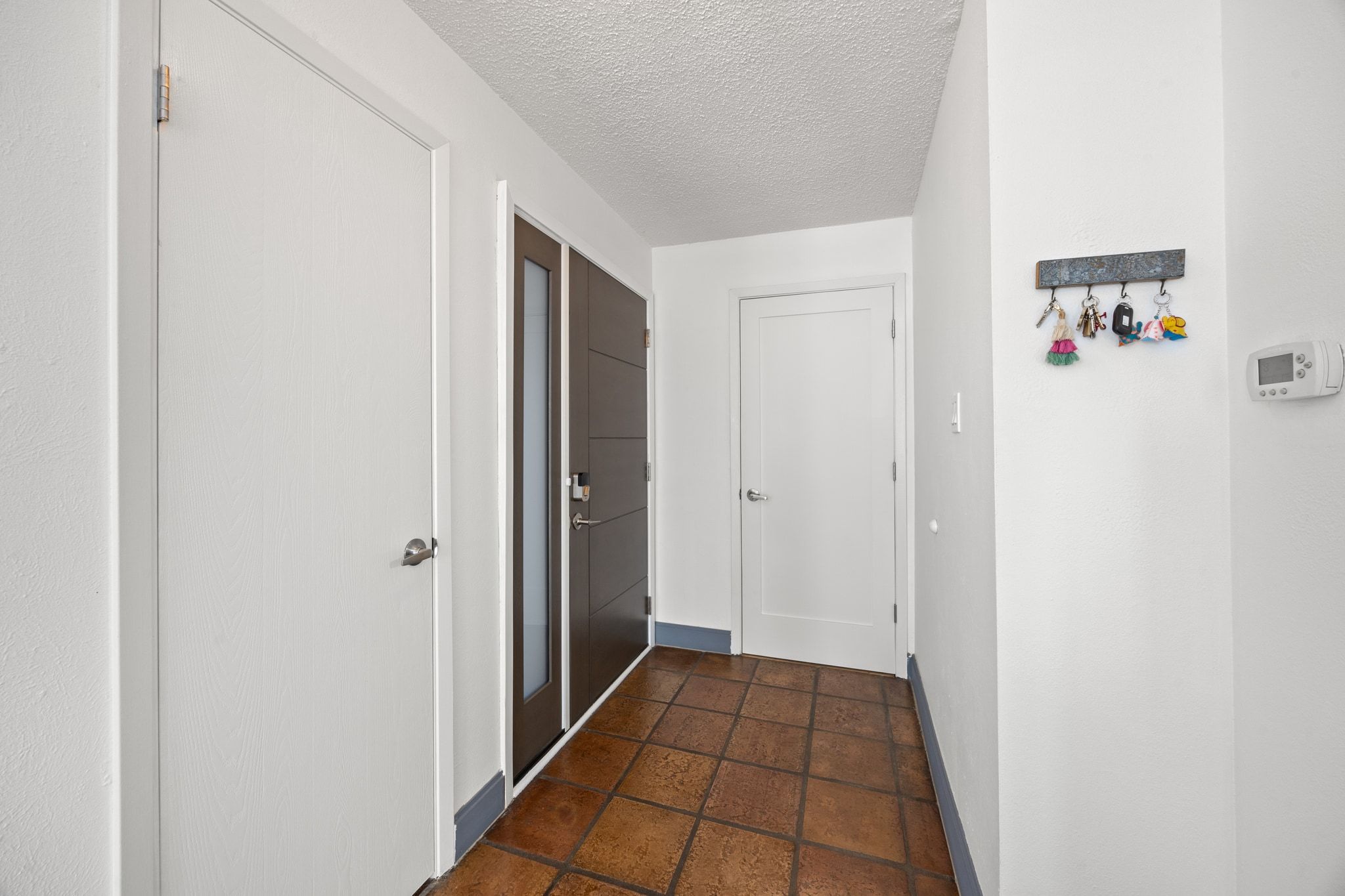 7256 Coronado Circle Austin, TX 78752 - Photo 8 of 26 Hallway with a textured ceiling and stone tile floors