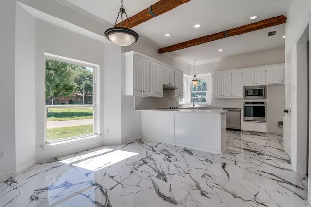 a kitchen with stainless steel appliances kitchen island granite countertop a sink window and cabinets