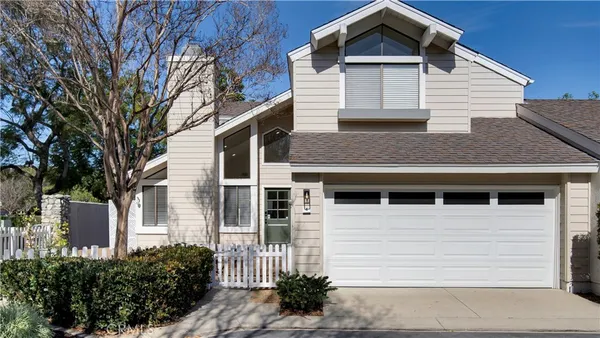 a house that has a large window and potted plants