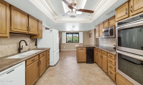 a kitchen with stainless steel appliances granite countertop a sink and dishwasher a stove top oven with wooden floor