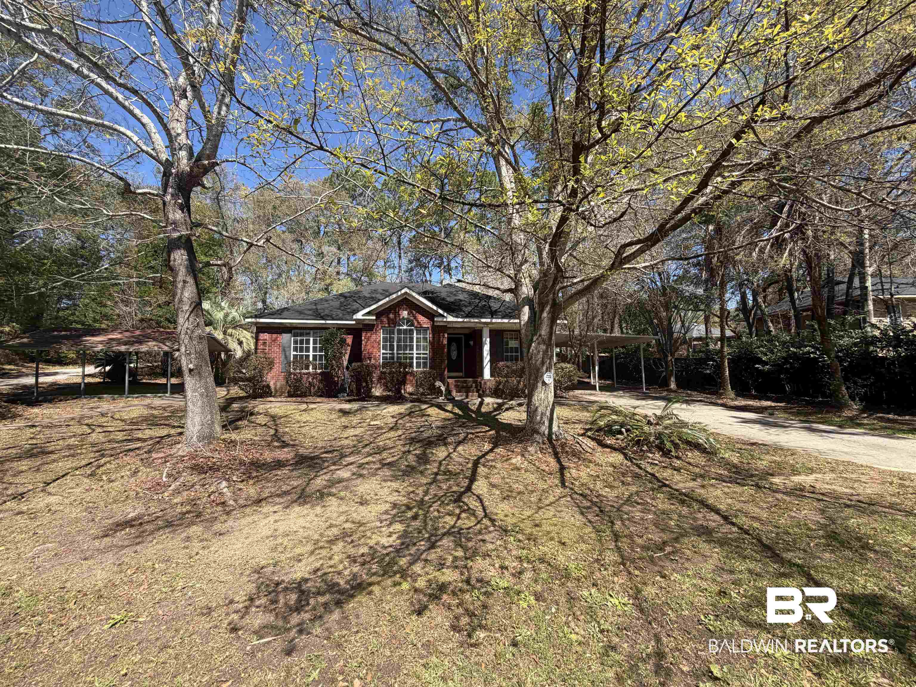 7067 Pinehill Road Daphne, AL 36526 - Photo 1 of 18 Ranch-style house featuring an attached carport, brick siding, covered porch, driveway, and a front yard