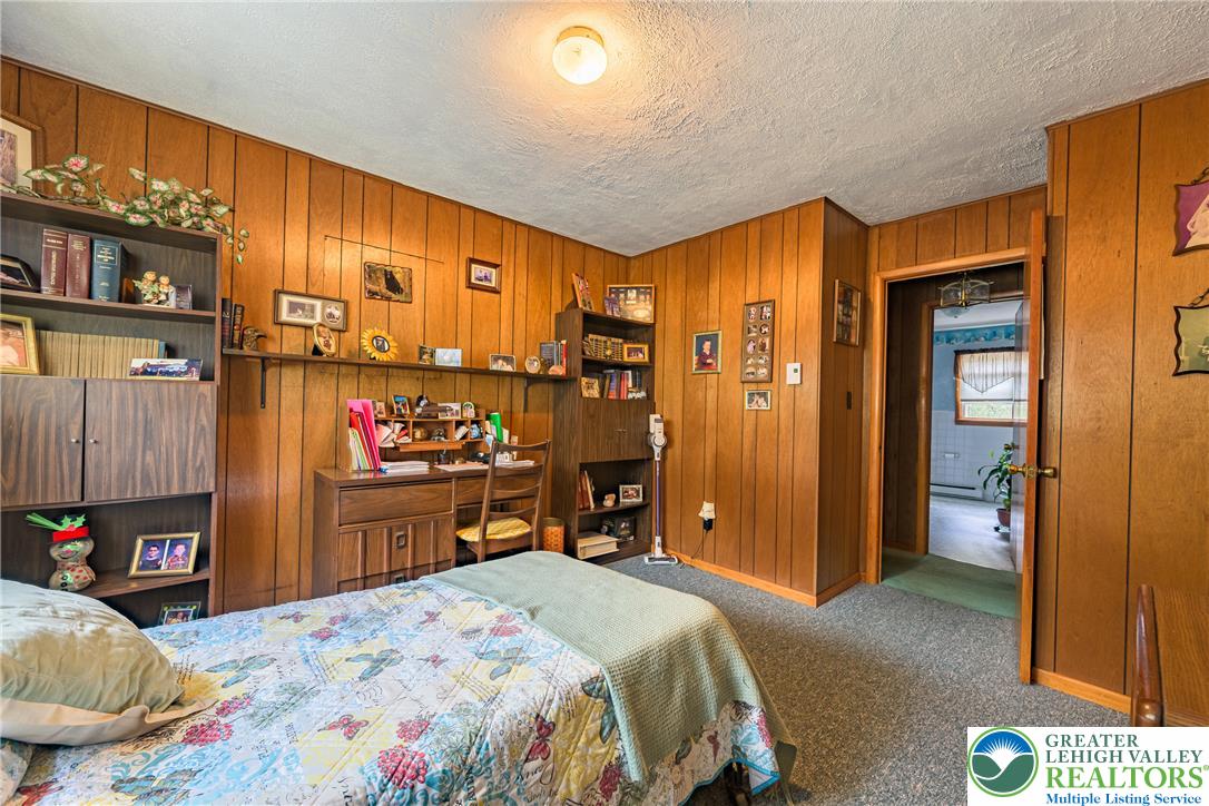 678 Interchange Road Kresgeville, PA 18333 - Photo 24 of 45 A cozy bedroom features wood paneling and a dedicated study nook for quiet productivity.
