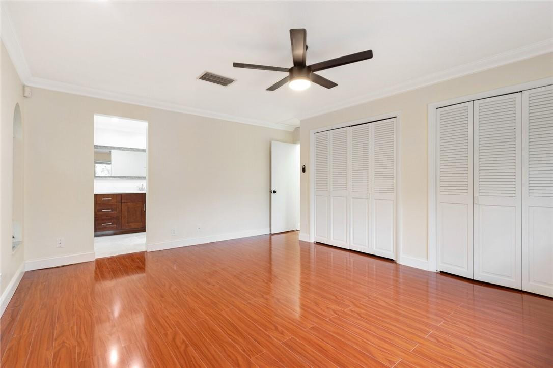 3420 Spring Bluff Place, Unit 39 Lauderhill, FL 33319 - Photo 18 of 32 a view of an empty room with wooden floor and a ceiling fan