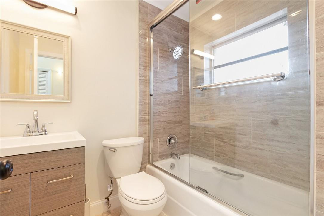 3420 Spring Bluff Place, Unit 39 Lauderhill, FL 33319 - Photo 24 of 32 a bathroom with a toilet a sink a mirror a bathtub and shower
