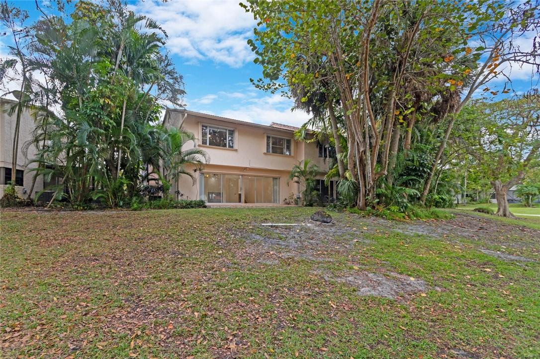 3420 Spring Bluff Place, Unit 39 Lauderhill, FL 33319 - Photo 32 of 32 a view of a house with a yard and large trees