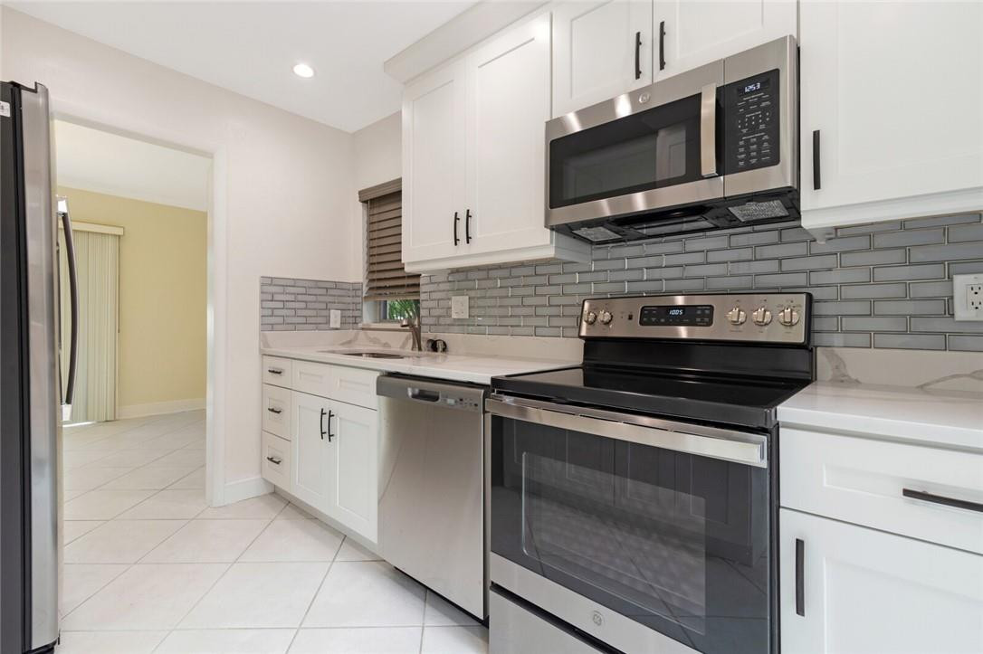 3420 Spring Bluff Place, Unit 39 Lauderhill, FL 33319 - Photo 6 of 32 a kitchen with stainless steel appliances granite countertop white cabinets and a stove top oven