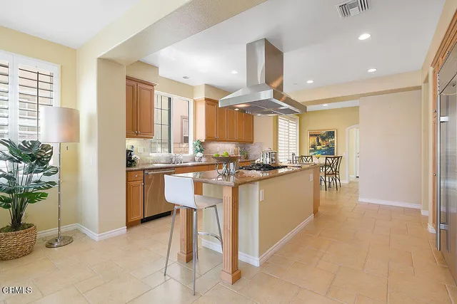 a kitchen with stainless steel appliances kitchen island granite countertop a table and chairs