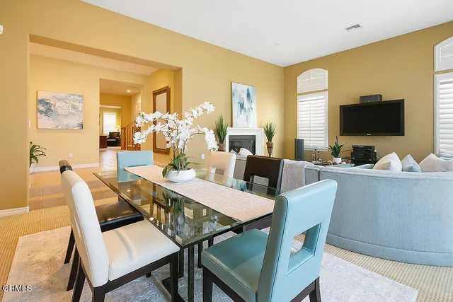 a living room with furniture a large window and a dining table