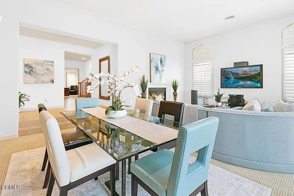 a living room with furniture a large window and a dining table