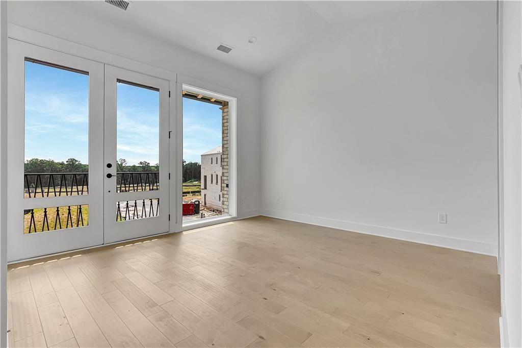 180 Rolison Way Fayetteville, GA 30214 - Photo 18 of 55 a view of an empty room with wooden floor and windows