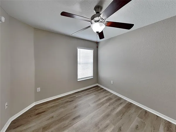 an empty room with a window and a fan