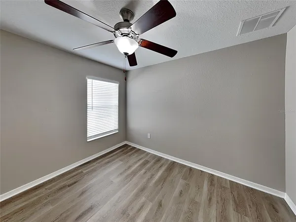 an empty room with a window and a fan