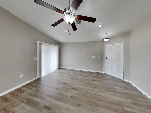 a view of an empty room with a ceiling fan